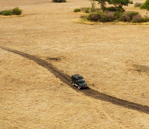 Vehicle on a dirt road driving on a plain in Kafue National Park
